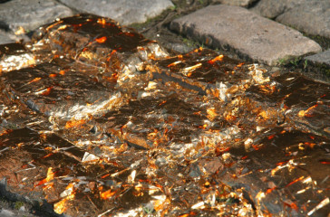 Copper plastic is broken across pavement slabs.
