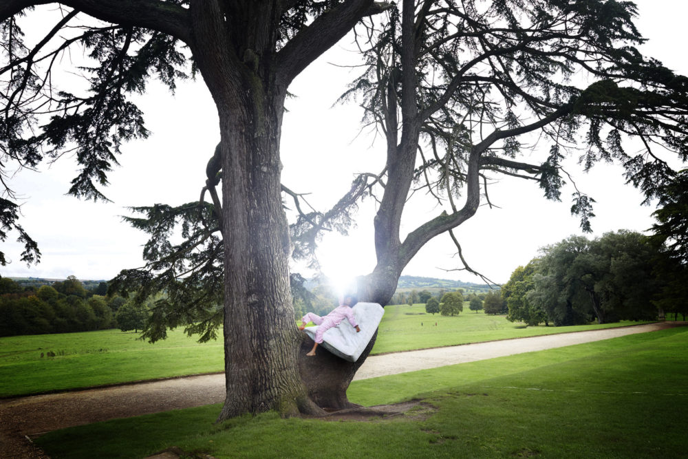 Chisara Agor, Creative Exchange Lab artist in a tree lying on a mattress