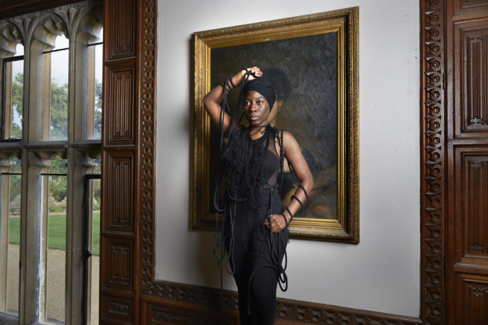 Julene Robinson, Creative Exchange Lab artist standing in front of a portrait at Arts Mansion